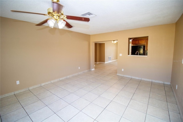 tiled spare room featuring a textured ceiling and ceiling fan