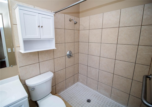 bathroom featuring tiled shower, vanity, and toilet