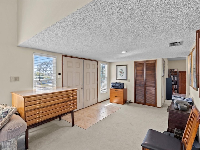 entryway featuring light colored carpet and a textured ceiling