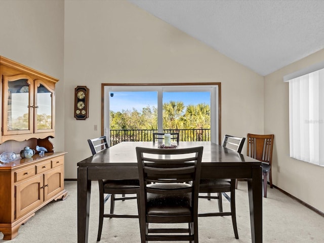 carpeted dining room with lofted ceiling