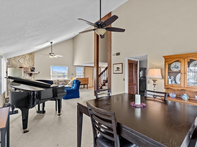 carpeted dining area featuring ceiling fan, a textured ceiling, and high vaulted ceiling