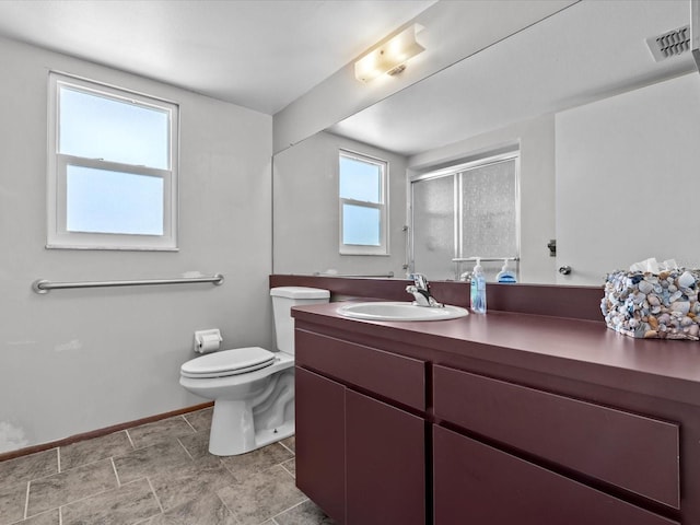 bathroom featuring vanity, toilet, and a shower with shower door