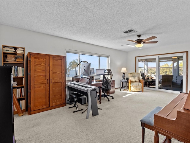 office area with ceiling fan, light colored carpet, and a textured ceiling