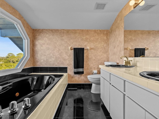 bathroom featuring tile patterned flooring, vanity, toilet, and tiled tub