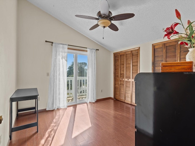 interior space with a textured ceiling, ceiling fan, wood-type flooring, and lofted ceiling