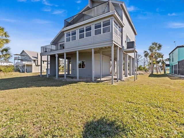 rear view of house with a yard, a sunroom, and a balcony