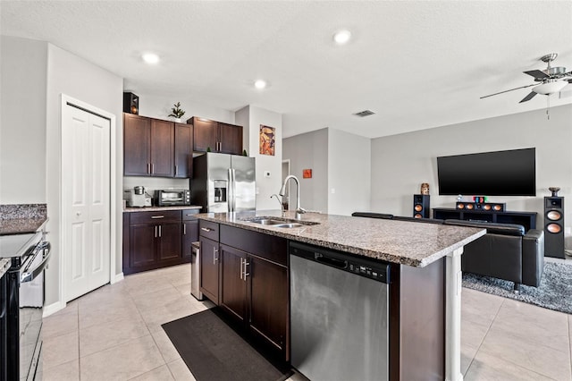 kitchen with dark brown cabinetry, sink, stainless steel appliances, a center island with sink, and light tile patterned floors