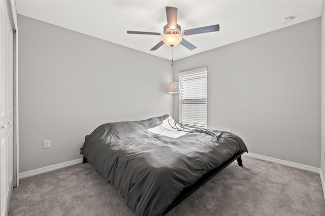 carpeted bedroom with ceiling fan and a closet