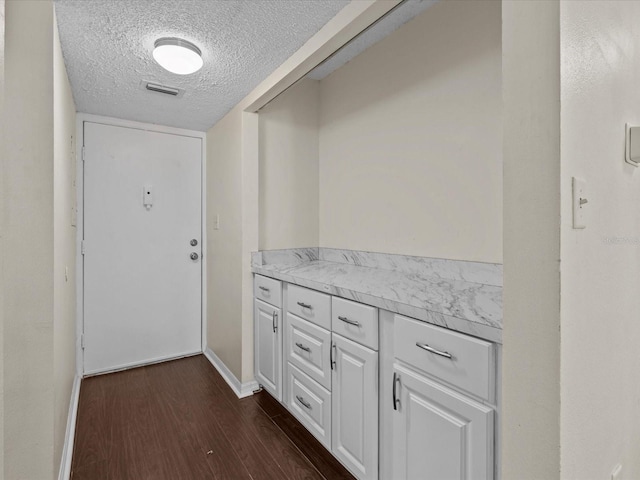 interior space featuring dark hardwood / wood-style flooring and a textured ceiling