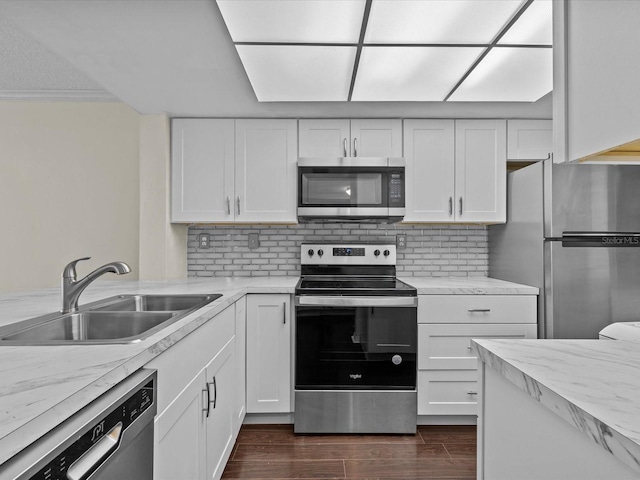 kitchen with white cabinets, decorative backsplash, stainless steel appliances, and sink