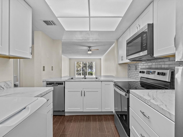 kitchen featuring dark hardwood / wood-style flooring, white cabinetry, sink, and appliances with stainless steel finishes