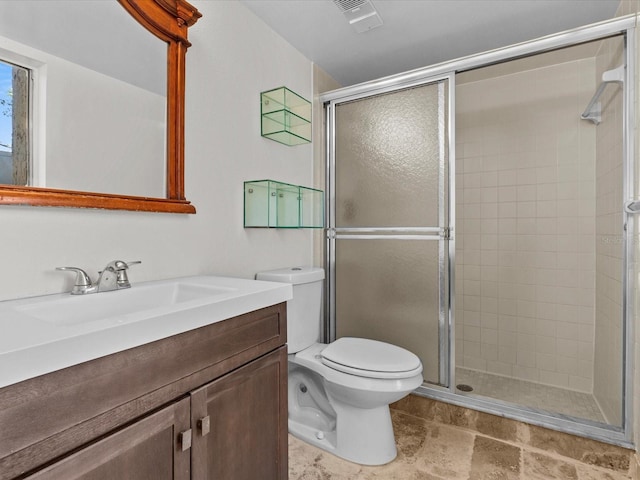 bathroom with vanity, a shower with shower door, and toilet