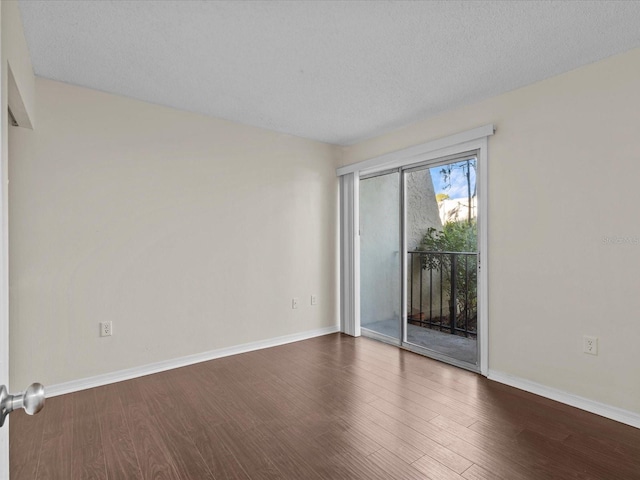 empty room featuring dark hardwood / wood-style flooring and a textured ceiling