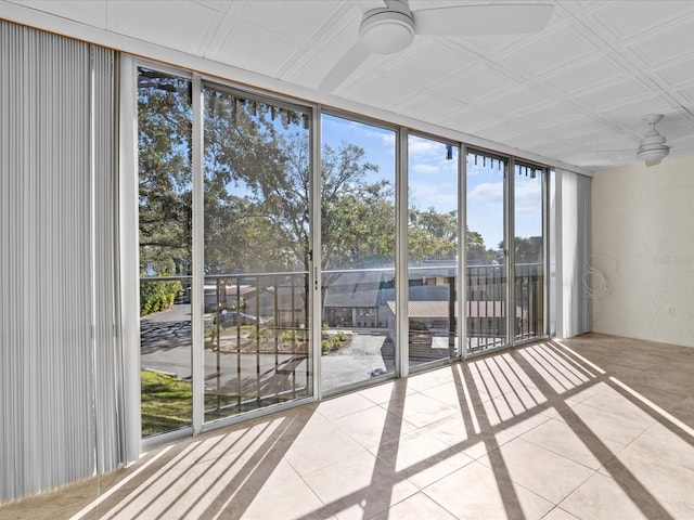 unfurnished sunroom with ceiling fan