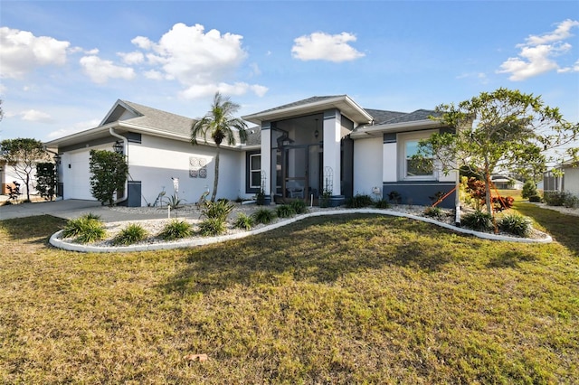 view of front of home featuring a garage, a front lawn, and a sunroom