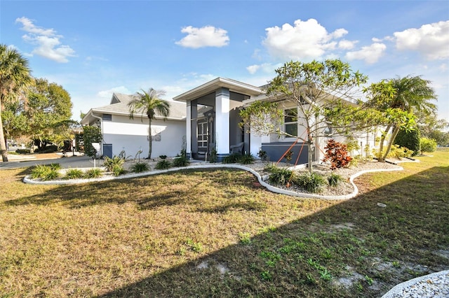 view of front facade with a front yard and stucco siding