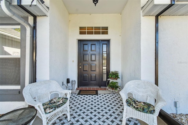 doorway to property featuring stucco siding