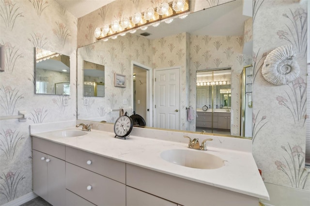 full bathroom featuring double vanity, a sink, and wallpapered walls