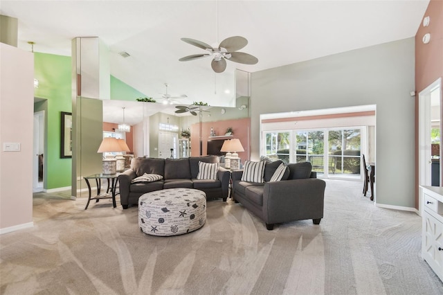 living area with high vaulted ceiling, light carpet, baseboards, and ceiling fan with notable chandelier