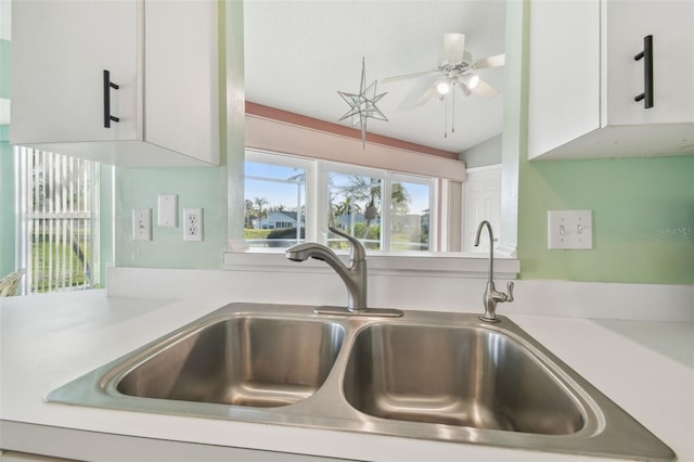 details with a ceiling fan, light countertops, white cabinets, and a sink