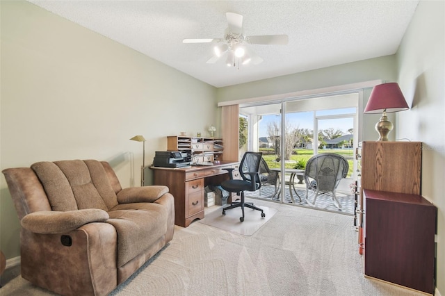 office space featuring ceiling fan, a textured ceiling, and light colored carpet