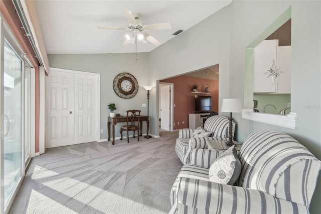 living area featuring lofted ceiling, light colored carpet, a ceiling fan, baseboards, and visible vents