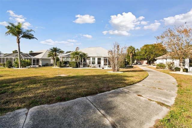 view of front of property with a front yard, glass enclosure, and a residential view