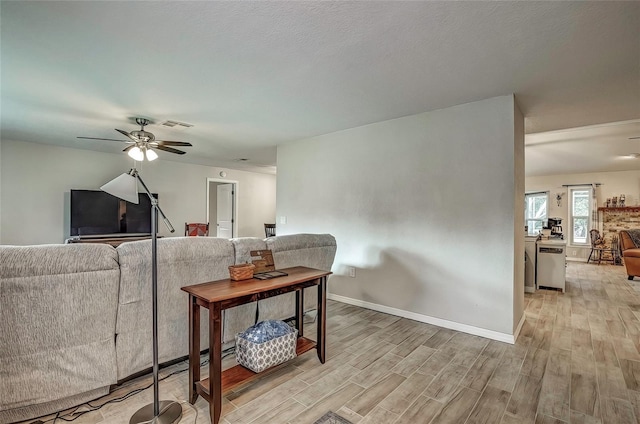 living room featuring light hardwood / wood-style flooring and ceiling fan