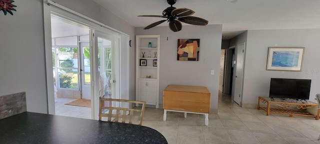 doorway with ceiling fan, plenty of natural light, built in features, and light tile patterned floors