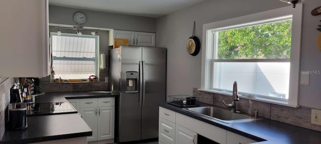 kitchen featuring white cabinetry, stainless steel fridge, tasteful backsplash, and sink