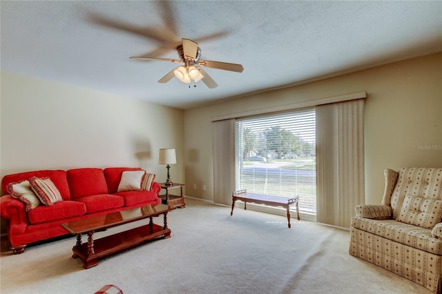 carpeted living room with ceiling fan and a textured ceiling