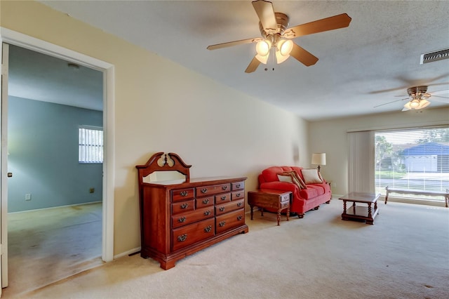 living area with light carpet and ceiling fan