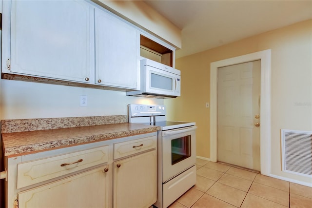 kitchen with light tile patterned floors and white appliances