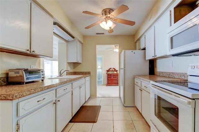 kitchen featuring ceiling fan, sink, light tile patterned floors, white appliances, and white cabinets