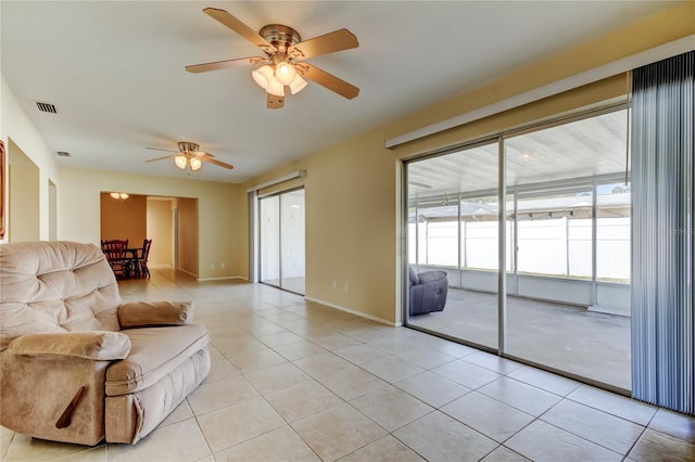 unfurnished living room featuring light tile patterned floors, ceiling fan, and a healthy amount of sunlight