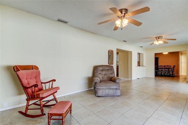 living area with light tile patterned floors and ceiling fan