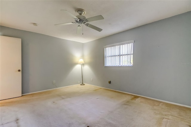 empty room featuring ceiling fan and light carpet