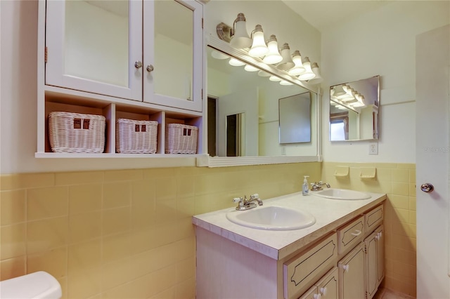 bathroom featuring vanity and tile walls