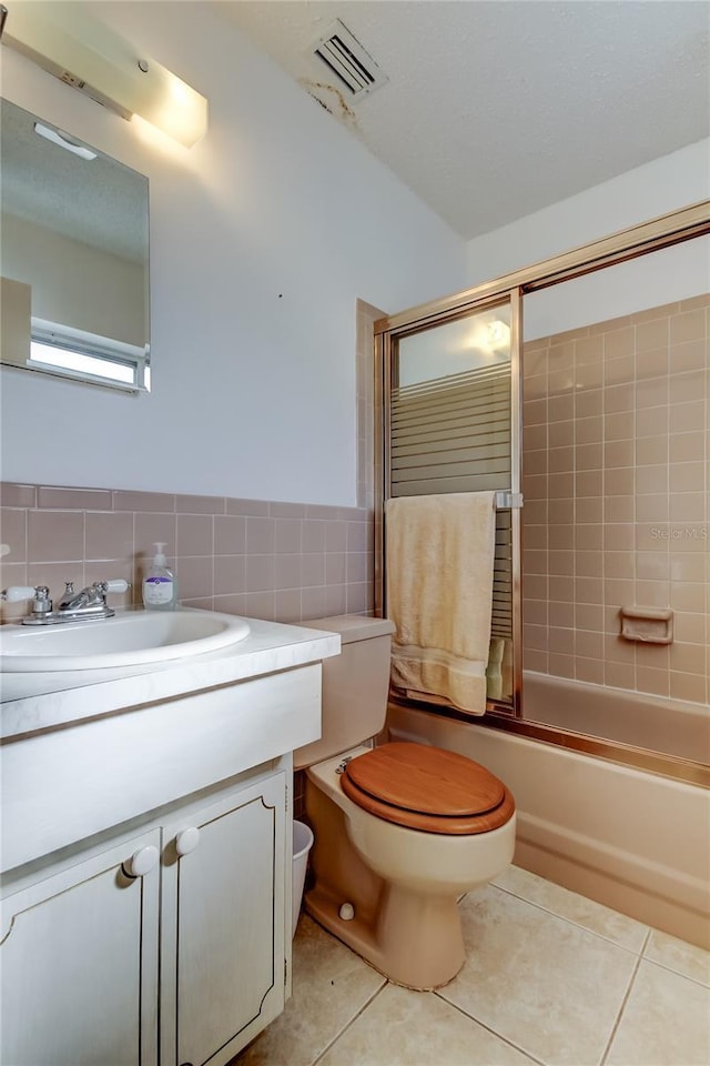 full bathroom with tile patterned flooring, vanity, toilet, and tile walls