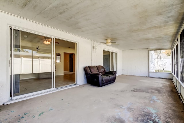 unfurnished sunroom with ceiling fan