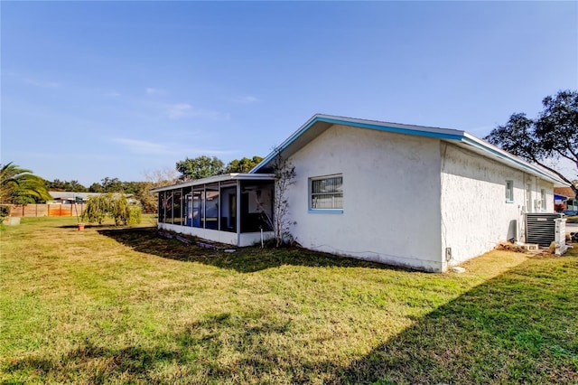 back of property featuring a sunroom, a yard, and cooling unit