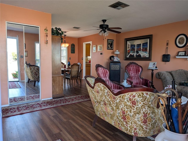 living room featuring ceiling fan and dark hardwood / wood-style flooring