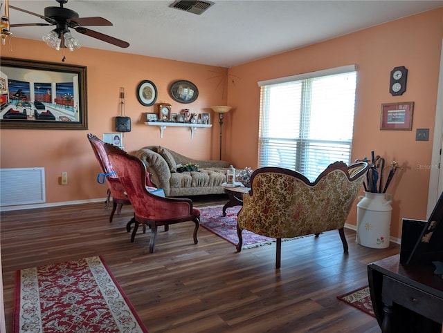 living room featuring ceiling fan and dark hardwood / wood-style floors