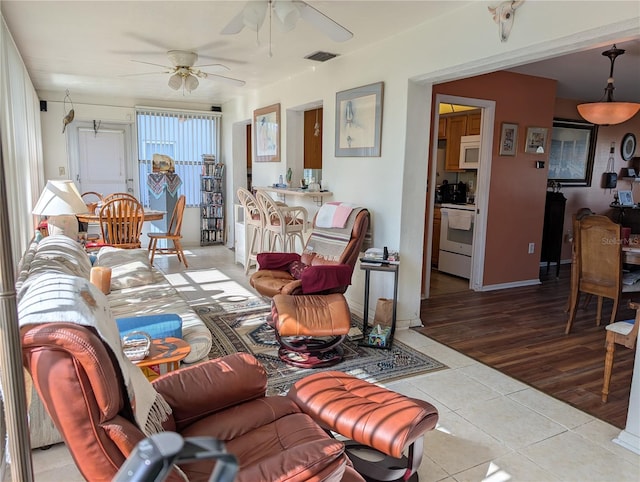 living room with ceiling fan and light tile patterned flooring