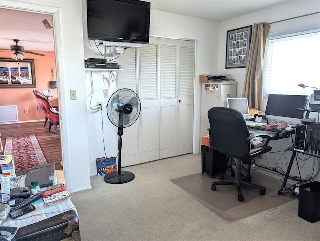 carpeted office space with ceiling fan