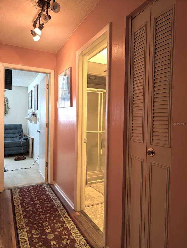 hall featuring wood-type flooring and a textured ceiling