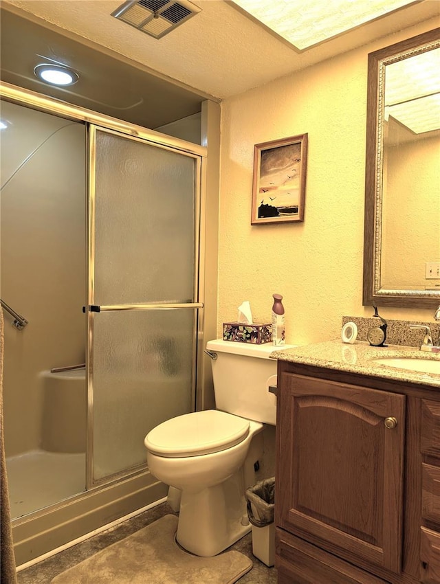 bathroom with tile patterned flooring, vanity, an enclosed shower, and toilet