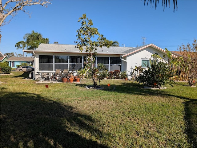 rear view of property featuring a lawn