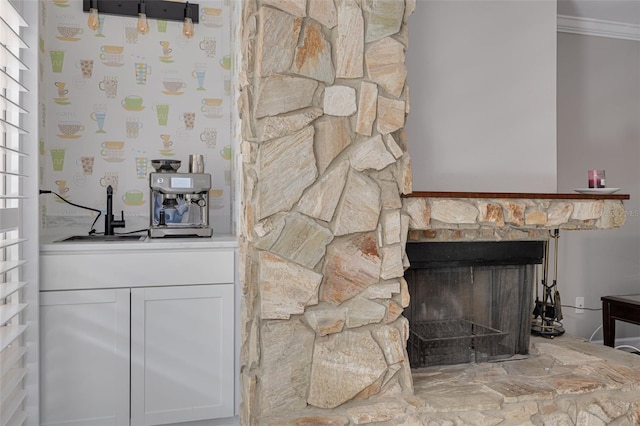 interior details featuring a stone fireplace and ornamental molding