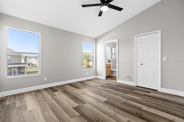 unfurnished bedroom featuring hardwood / wood-style flooring, ceiling fan, lofted ceiling, and connected bathroom